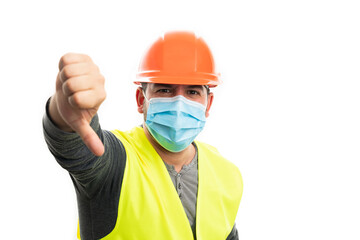 Builder man wearing surgical mask making thumb-down gesture