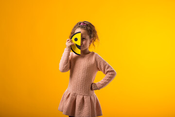 Sad kid girl holding happy half face emoticon. Mental health, psychology and children's emotions...