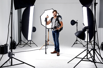 Photographer, portrait and lighting with equipment in studio for career, behind the scenes or...