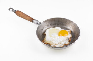 old aluminum frying pan with fried egg isolated on white background