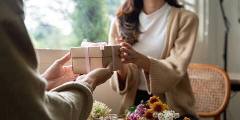 Romantic young asian couple embracing giving present in living room at home. Fall in love. Valentine concept