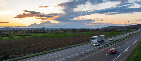 Transportation trucks in high speed driving on a highway through rural landscape. Fast blurred...