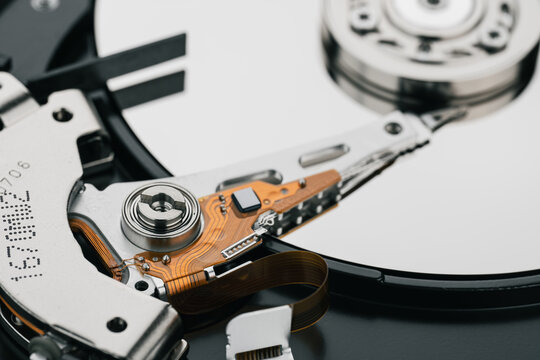 Hard drive isolated on white background. HDD. Major components of a 3.5-inch SATA hard disk drive: platter, spindle, actuator, actuator arm. Disk head above the plates	