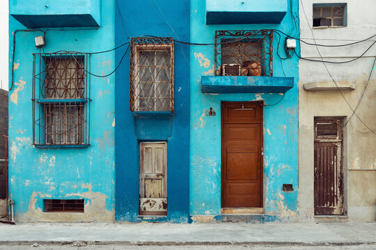 Rough painted facades of buildings with bars on the windows, Havana, Cuba