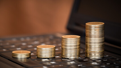 Gold coins on a laptop keyboard. Money savings, business success banner. Online banking.