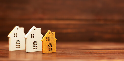 Houses on wooden background, buying, selling or renting home. Real estate investment banner with copy space.