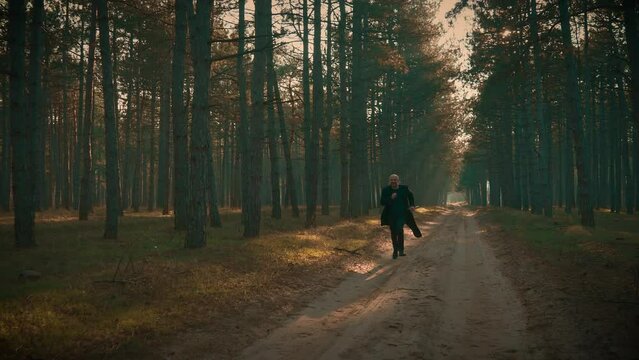 Serial killer running after victim in forest swinging sharp axe, embodying essence of evil and death alone in dark forest. Maniac Murder and crime, Halloween horror day concept