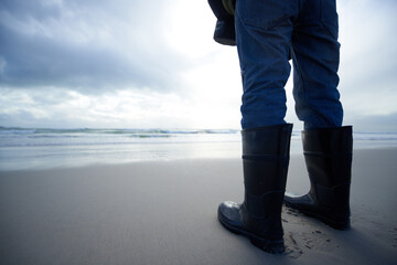 Travel, boots and shoes of person at beach for ocean, tourism and walking in sand. Adventure,...