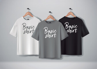 Basic Black, gray and white short sleeve T-Shirts Mock-up clothes set hanging isolated on wall. Front side view with lettering for your design or logo.