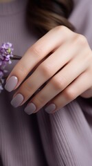 Fototapeta premium Beautiful glossy gray soft light nude manicure, vertical photo,