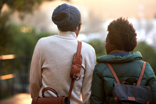 Back view, university student and friends in outdoor on campus, contemplate and relax with backpack in cold weather. College, interracial and classmate for chill, think and plan for assignment.
