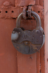a large old iron lock hanging on a metal door close-up
