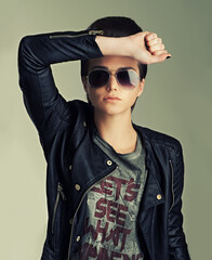 Woman, studio and punk with confidence, pose and sunglasses for gen z, trendy and fashion. Female...