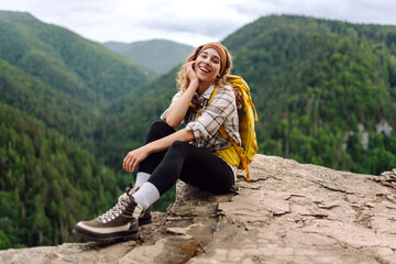 Young woman with backpack on mountain peak enjoying nature. Hiking.Travel and tourism. Active lifestyle. © maxbelchenko