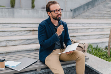 handsome busy bearded man working in park