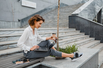attractive business woman working outside on laptop