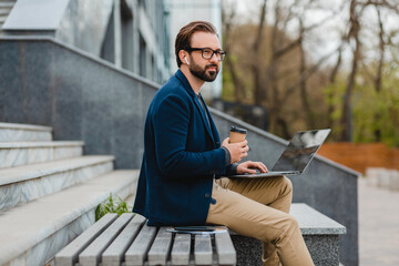 handsome busy bearded man working in park