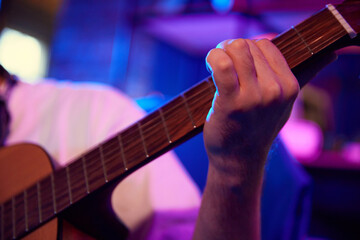 Fototapeta premium Close up photo of young man, music artist, blogger playing guitar while holds online streaming or record video-lesson. Concept of youth people with social media and smart working, lifestyle, art.