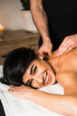 Fototapeta na wymiar A professional masseur gives a massage to a young woman.Beautiful young woman enjoying massage in spa salon. Beauty treatment, skin care, wellbeing.Concept of massage and spa treatments