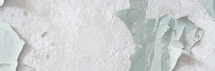 Peeling paint on the wall. Old concrete wall with cracked flaking paint. Weathered rough painted surface with patterns of cracks and peeling. Grunge texture for background and design. High resolution.