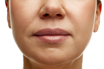 Cropped portrait of middle-aged woman with full moisturized pink lips with natural gloss and...