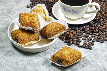 plate of Fried Makrout or makroud - Algerian semolina, dates and honey sweets, traditional North Africa sweet food for islam on grain coffee and cup