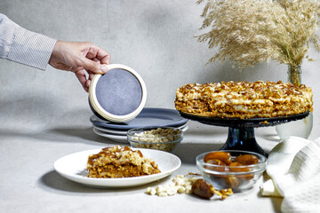 Homemade Russian Honey dates and peanuts cake. Honey cake Medovik and hand hold box 