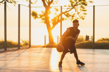 black man doing sports, playing basketball on sunrise, active lifestyle, sunny summer morning