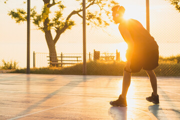 black man doing sports, playing basketball on sunrise, active lifestyle, sunny summer morning - obrazy, fototapety, plakaty