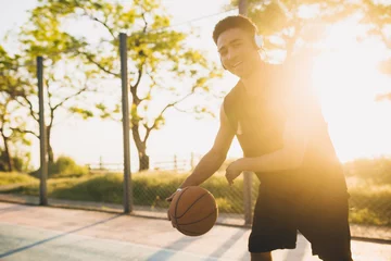 Kussenhoes black man doing sports, playing basketball on sunrise, active lifestyle, sunny summer morning © mary_markevich