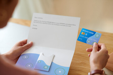 Woman reading letter from bank, containing credit card and personal loan offer information
