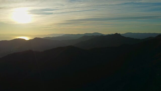 drone vista delle colline in Liguria. Sul fondo Rapallo. Mare e montagne al tramonto.
