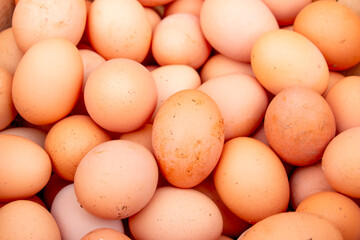 Pile of raw brown chicken eggs, top view.