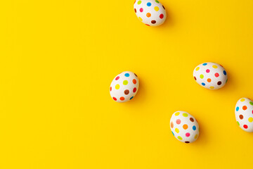 Spotty painted colorful easter eggs on yellow background.