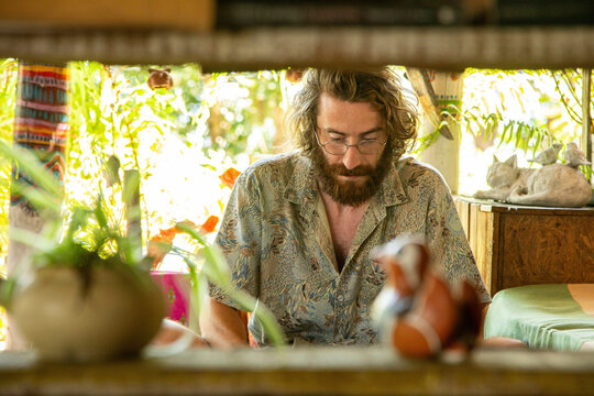 Young Man works on his laptop and phone in a restaurant in Northern Thailand, He is a digital Nomad working remotely.