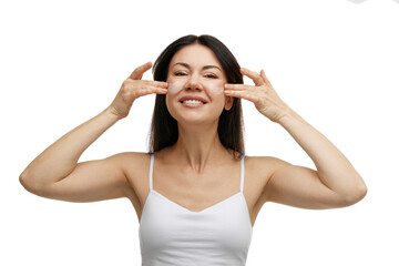 Fototapeta premium Portrait of happy brunette woman applies moisturized cosmetic product for facial skin against white studio background. Concept of beauty, antiaging procedures, self care, lifting and rejuvenation. Ad