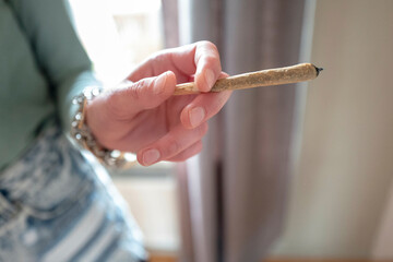 Hands of a woman holding a marijuana joint