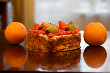valentine's day cake with two oranges on a brown glossy table top