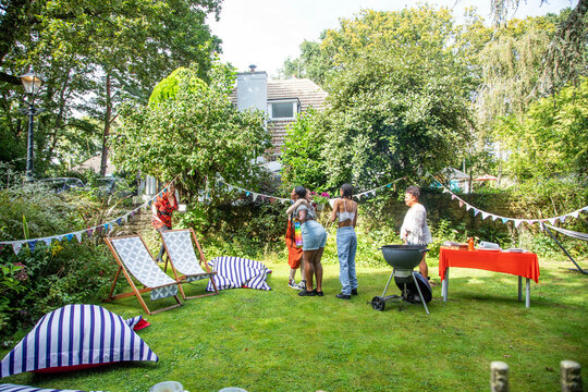Friends arriving at a summer garden BBQ party.