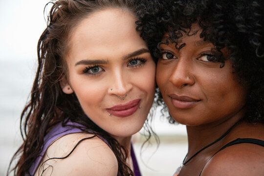Portrait of a black girl and her trans female friend posing on a beach