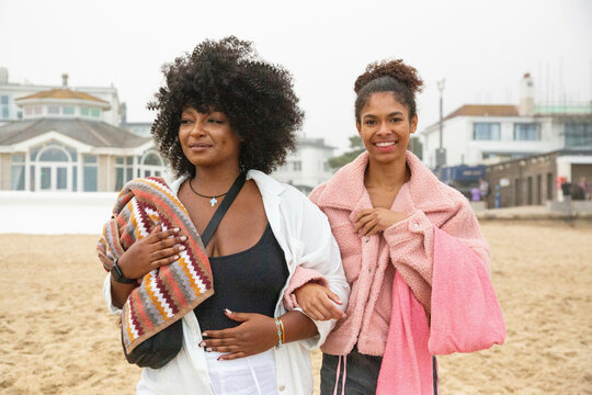 A portrait of mixed race sisters who have come to the beach to swim in the sea.