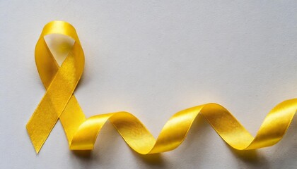 una cinta amarilla de concientizacion sobre el cancerslada sobre fondo blanco