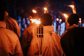 Crowd holding torches in night