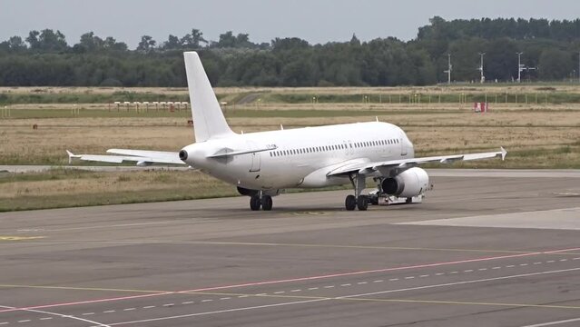 White Aircraft Pushing Back from the Airport Terminal