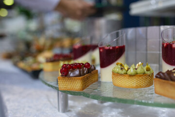 Colorful and delicious canapes and desserts on a glass shelf at a catering event