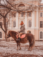 Naklejka premium boy is sad while sitting astride a pony