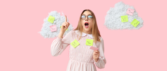 Young woman with raised index finger and many sticky notes on pink background. Reminder concept