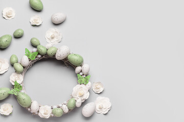 Easter wreath with flowers, eggs and butterflies on grey background