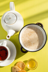 Warm and Inviting Breakfast Scene with Oatmeal, Tea, and Honey on Yellow Background