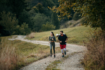 Obraz premium Active couple enjoying a morning run amidst breathtaking mountain scenery